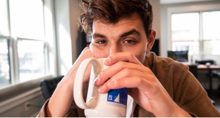 Man drinking coffee, looking at camera